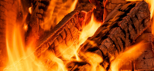 Brennendes Holz und Glut als Symbol für die Brennstoffe von Bauser